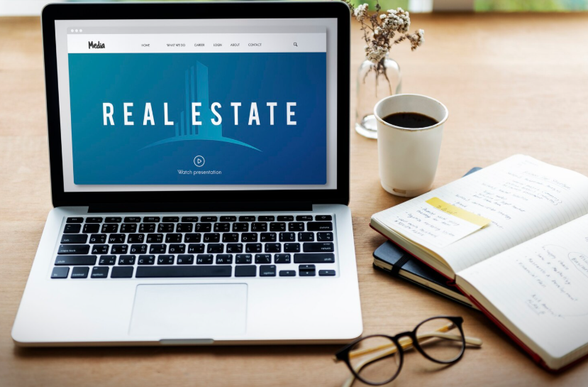 Laptop displaying a real estate market screen alongside notes, used for home value analysis.