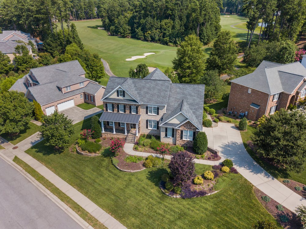 Aerial photo of a suburban neighborhood with landscaped homes, showcasing desirable community features.