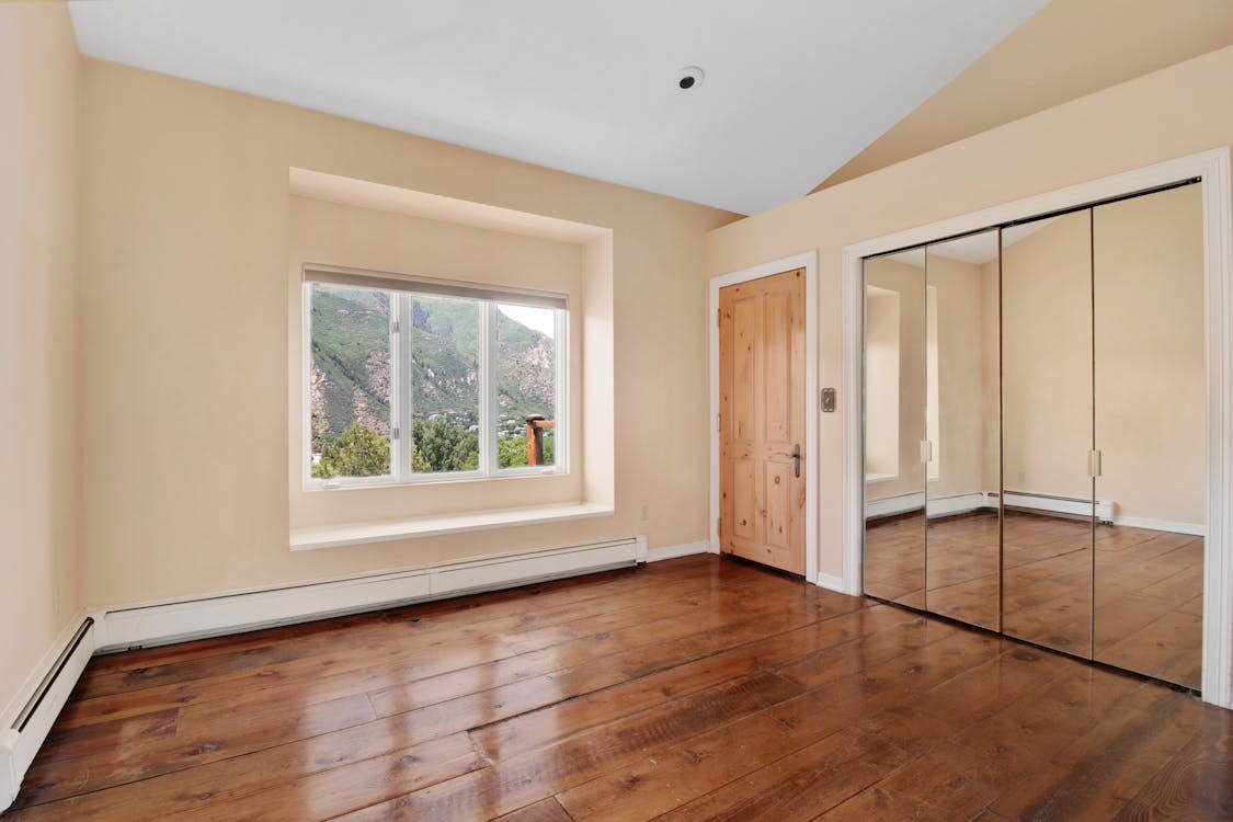 Bedroom with wide-plank hardwood flooring, showcasing a high-value flooring upgrade for resale.