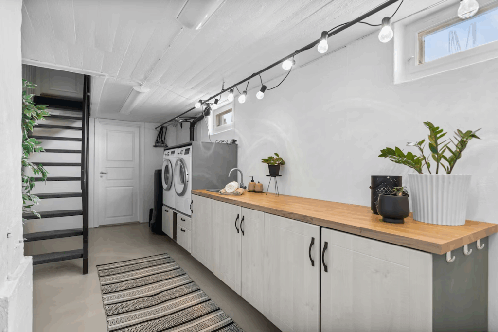 Finished garage conversion with laundry area and cabinetry, demonstrating a high-value functional living upgrade.